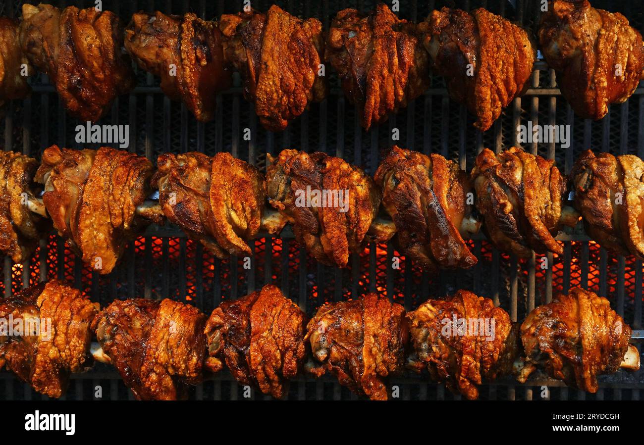 Schweinshaxen langsam bei Rotation Grill zubereitet Stockfoto