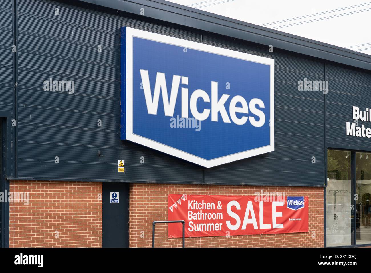 Wickes Logo und Geschäft in Oxford, mit einem Banner, das einen Sommerverkauf auf Küchen & Bädern, Großbritannien, anzeigt. Konzept: Heimwerkerarbeit, Heimwerkerarbeit Stockfoto