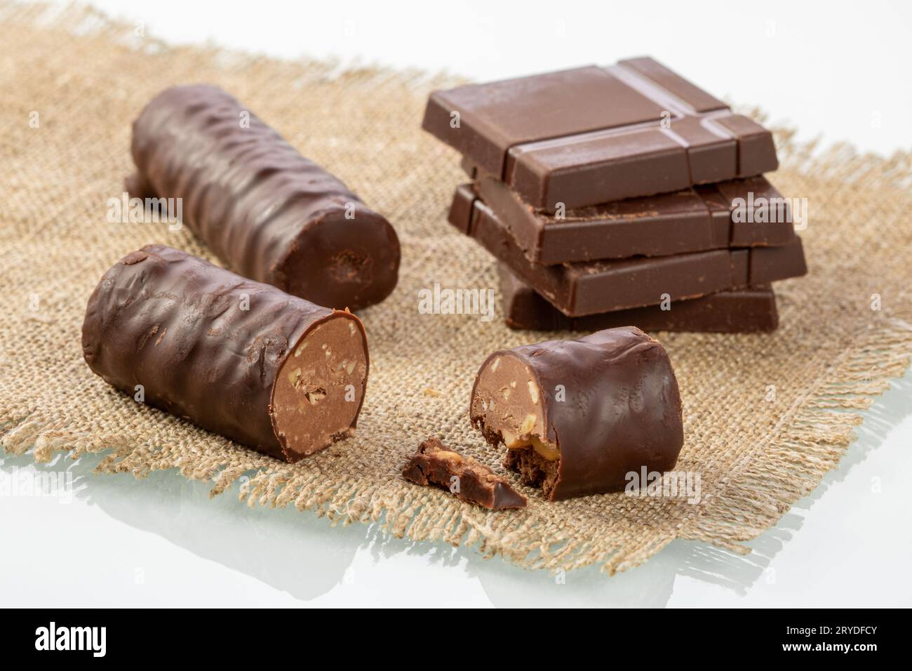 Schokoriegel stapeln und Schokoladenbonbons auf einer Sackleinen-Serviette in Nahaufnahme schneiden Stockfoto