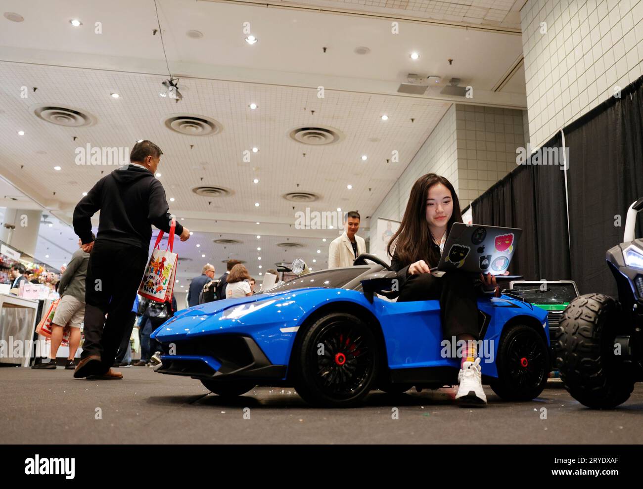 New York, Usa. September 2023 30. Eine Person arbeitet auf einem Laptop, während sie in einem Spielzeugauto sitzt, das auf der New York Toy Fair am Samstag, den 30. September 2023, im Jacob K. Javits Convention Center in New York City ausgestellt ist. Foto von John Angelillo/UPI Credit: UPI/Alamy Live News Stockfoto