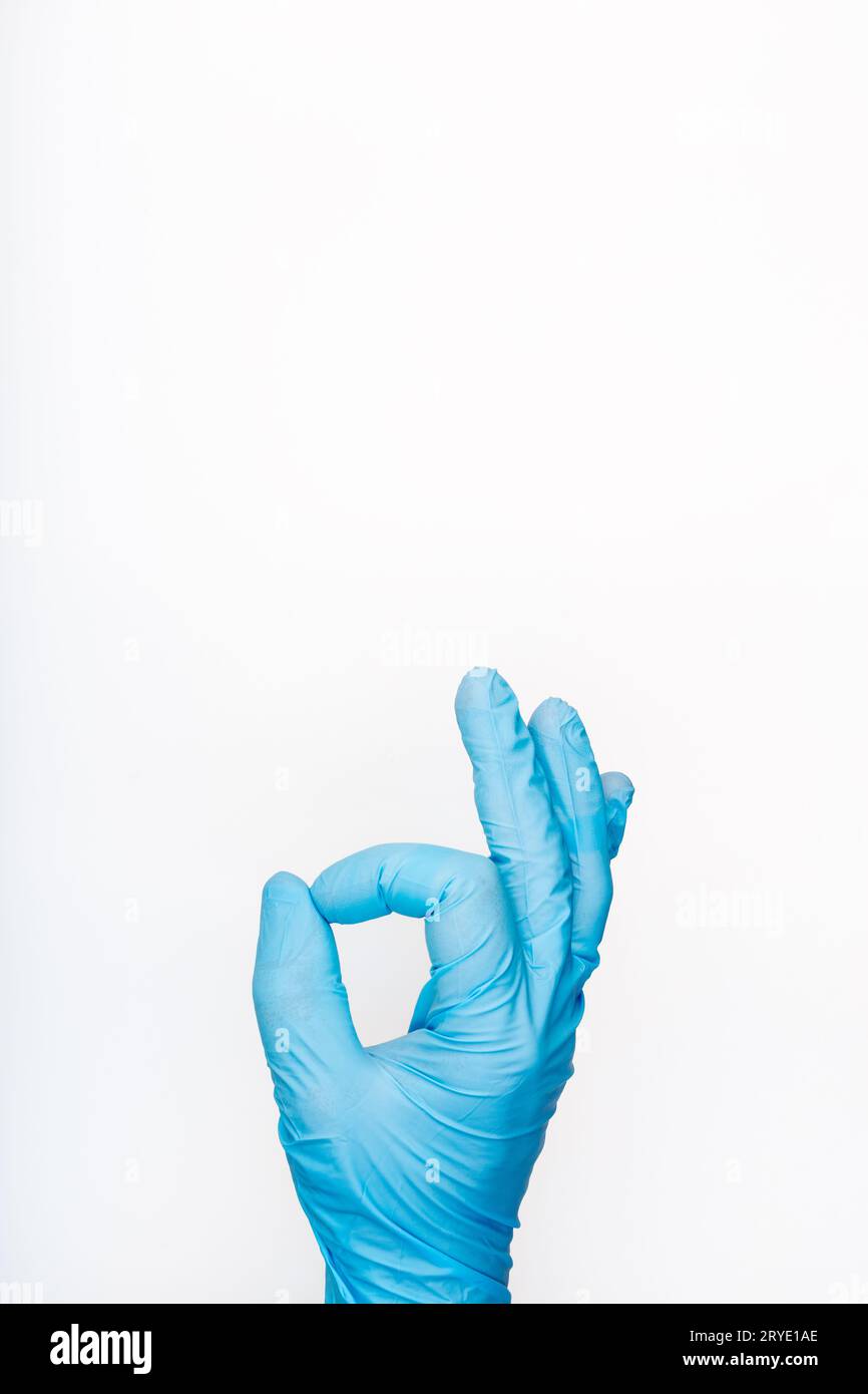 Hand in medizinischem Handschuh mit OK-Geste auf weißem Hintergrund Stockfoto
