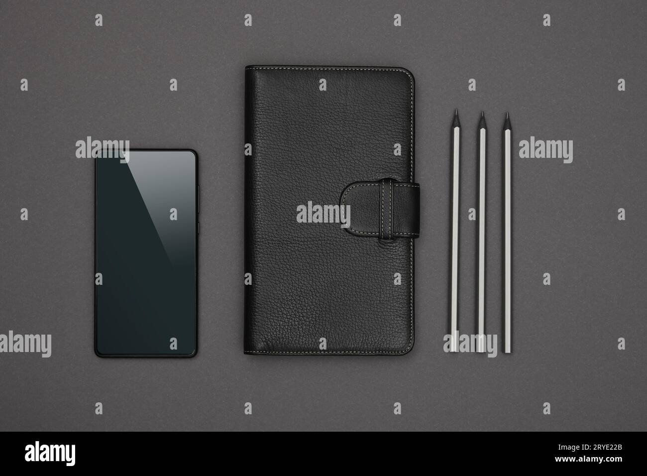 Schwarzes Notebook mit Lederbezug flach über Grau gelegt Stockfoto