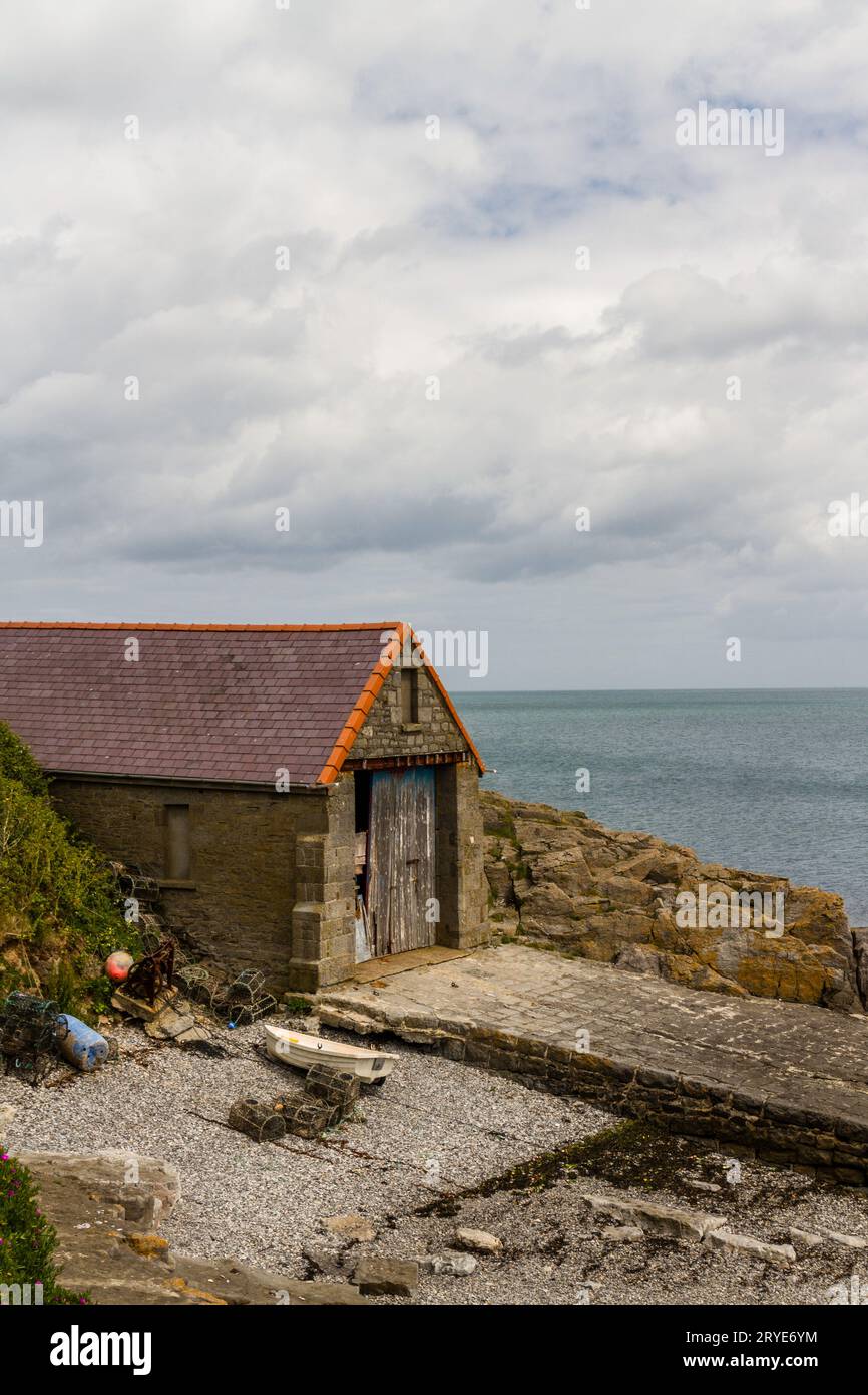Die alte Rettungsbootstation oder das alte Haus, jetzt veraltet und überflüssig, Moelfre, Anglesey, Nordwales, Vereinigtes Königreich, Hochformat Stockfoto