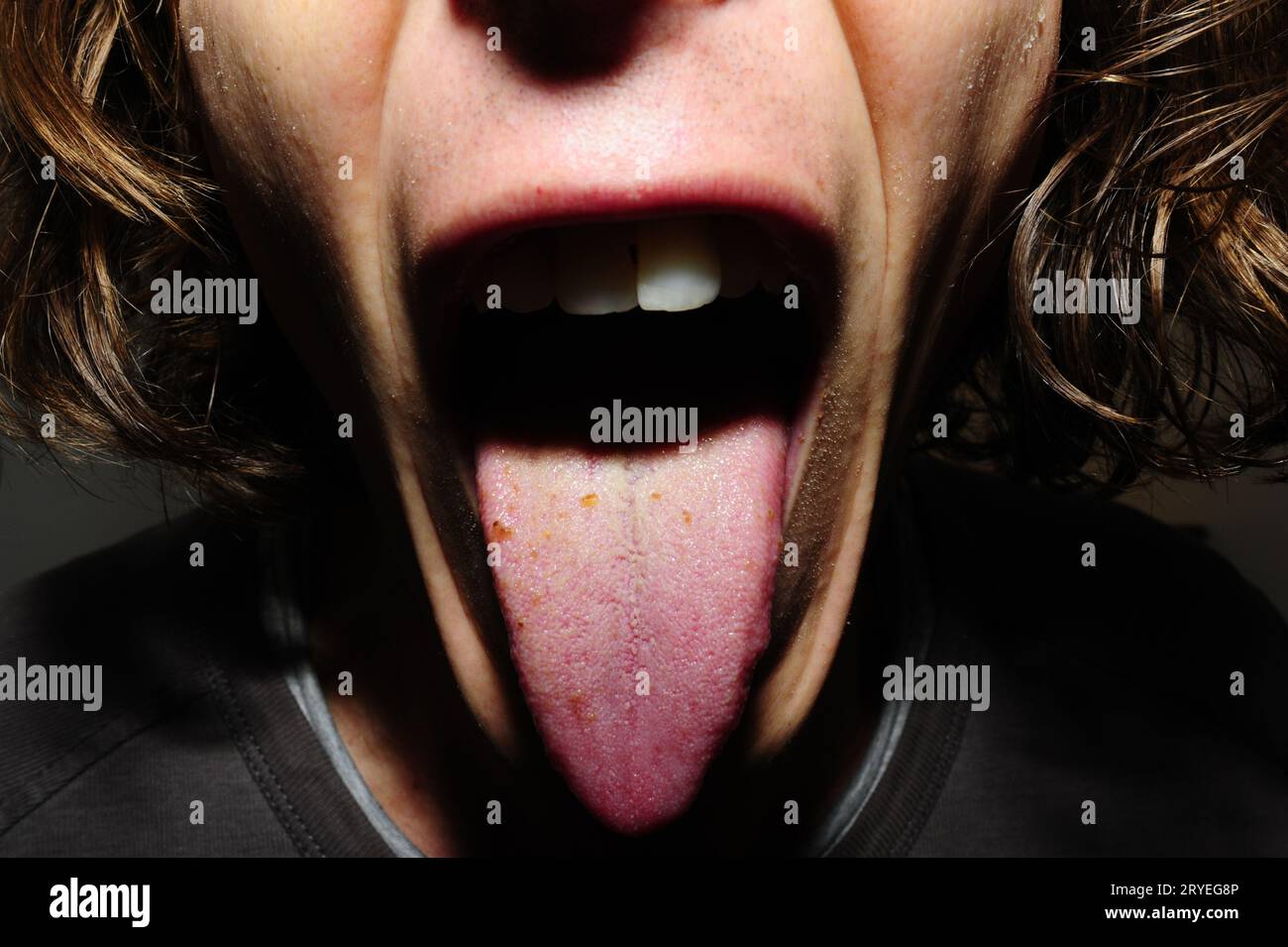 Ein Typ mit offenem Mund, der seine Zunge zeigt Stockfoto