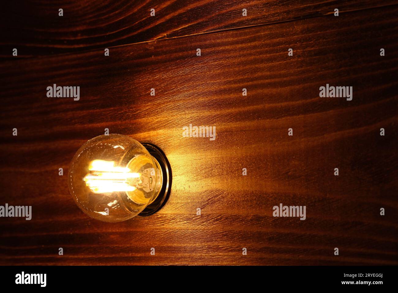 Eine Glühlampe über Holzoberfläche Stockfoto