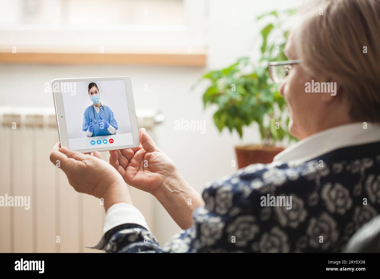 Ältere kaukasische Frau, die mit einer jungen E-Ärztin über einen Online-Videochat spricht Stockfoto