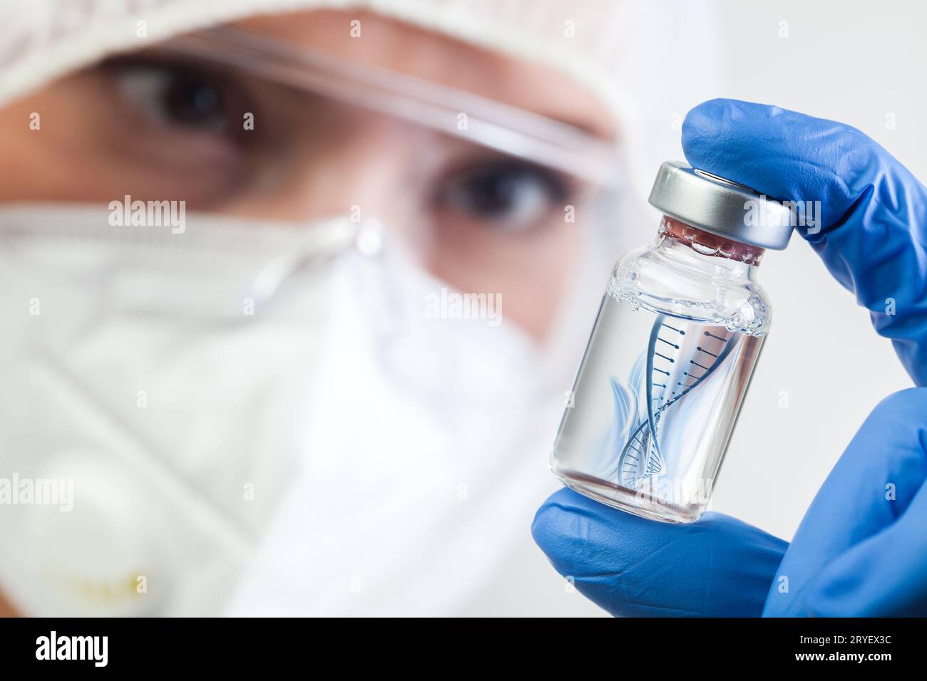Weibliche NHS-Mikrobiologin oder Laborbiotechnikerin, die Glasfläschchen mit DNA-Helixstrang hält, der in Flüssigkeit schwimmt Stockfoto