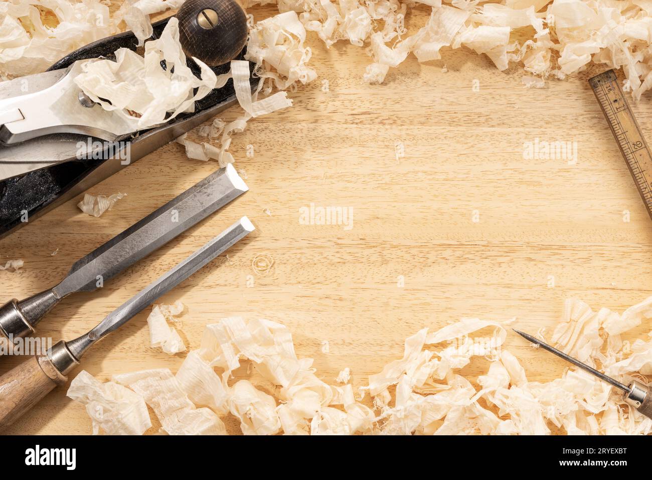 Tischlerei- oder Holzwerkhintergrund mit Kopierraum. Alte Zimmermannswerkzeuge und Holzspäne auf einer Werkbank Stockfoto