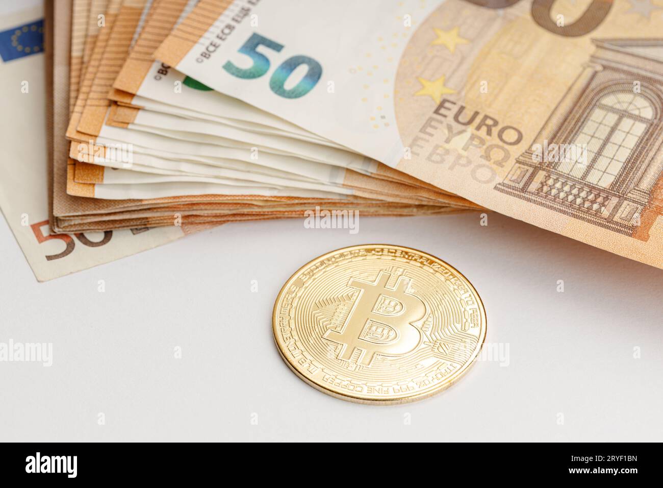 Bitcoin-Münzen und Euro-Banknoten. Blockchain Money versus fiat Money Concept Stockfoto