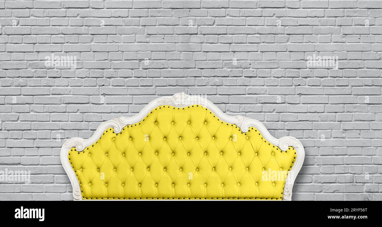 Gelbes chesterfield-Ledersofa auf Grau Stockfoto