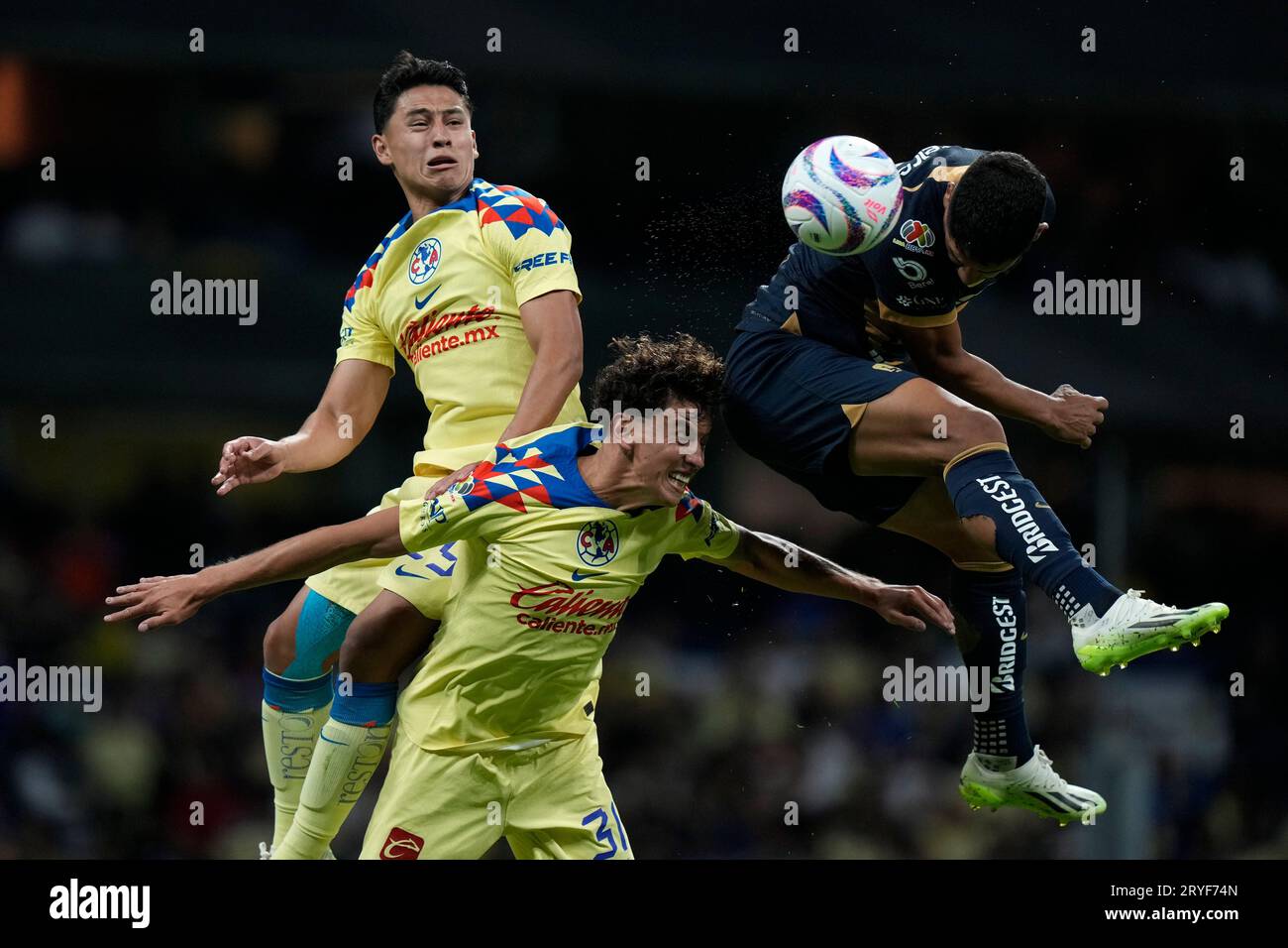 Pumas' Gabriel Fernandez, right, fights for the ball against America's Igor Lichnovsky, bottom left, and Ramon Juarez, top left, during their Mexican soccer league match in Mexico City, Saturday, Sept. 30, 2023. (AP Photo/Fernando Llano) Stockfoto