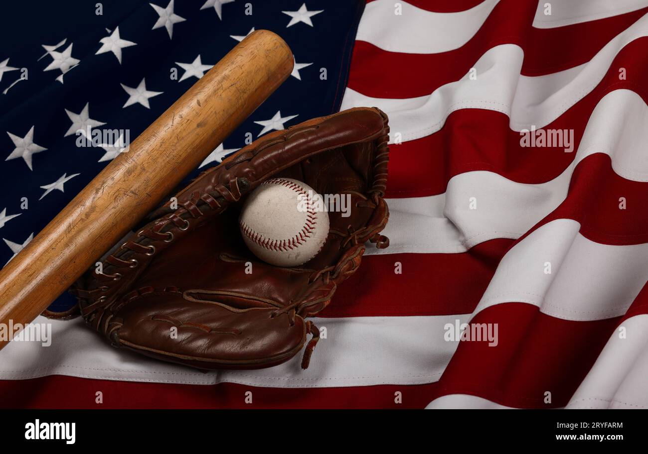 Baseballball, Schläger und Handschuh auf amerikanischer Flagge Stockfoto