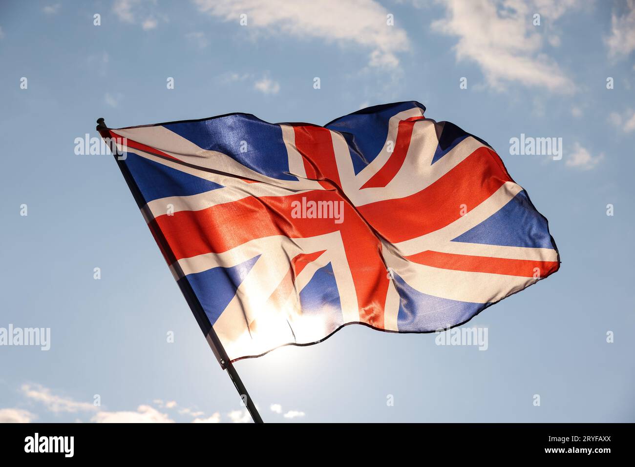 Britische Flagge winkt im wolkigen blauen Himmel Stockfoto