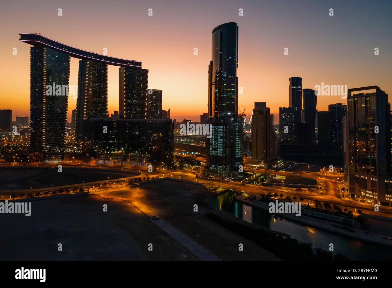 Zauberhafter Sonnenuntergang auf der Insel Al Reem in Abu Dhabi. Luftaufnahme der silhouettierten modernen Wolkenkratzer. Stockfoto