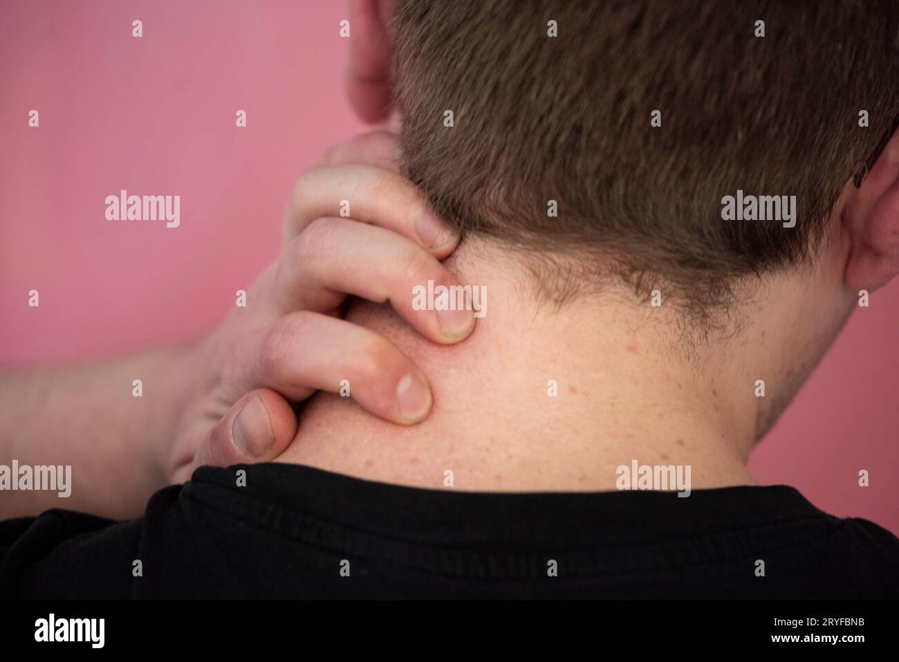 Person mit Nackenschmerzen, die den Hals hält Stockfoto