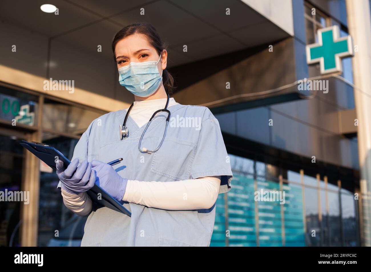 Weibliche Ärztin steht vor der Eingangstür des Krankenhauses Stockfoto