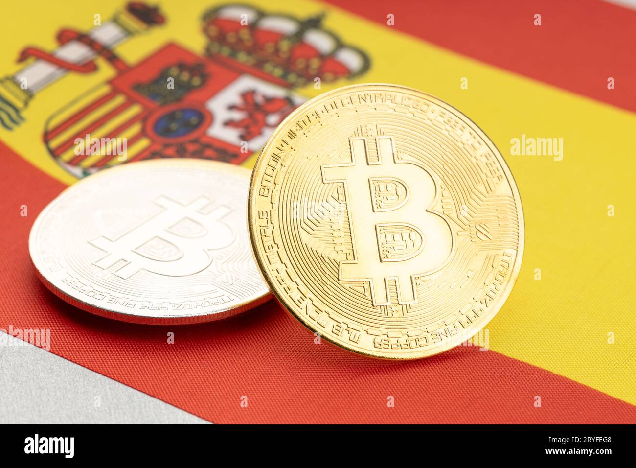 Bitcoin-Kryptowährungsmünzen auf der spanischen Nationalflagge. Krypto-Gesetz-Regulierung Konzept Stockfoto