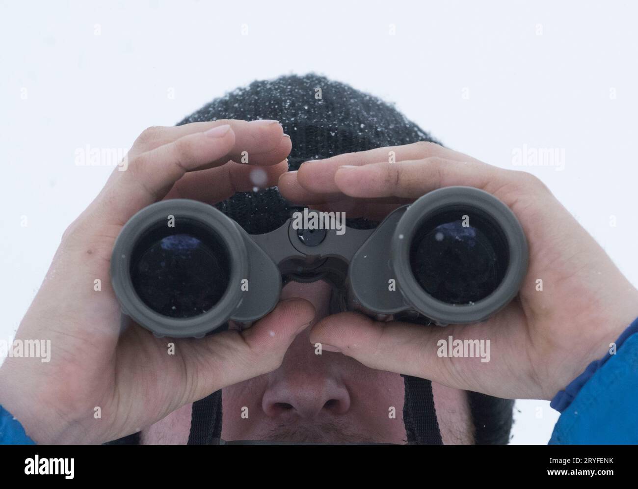 Eine Person, die durch ein Fernglas Stockfoto