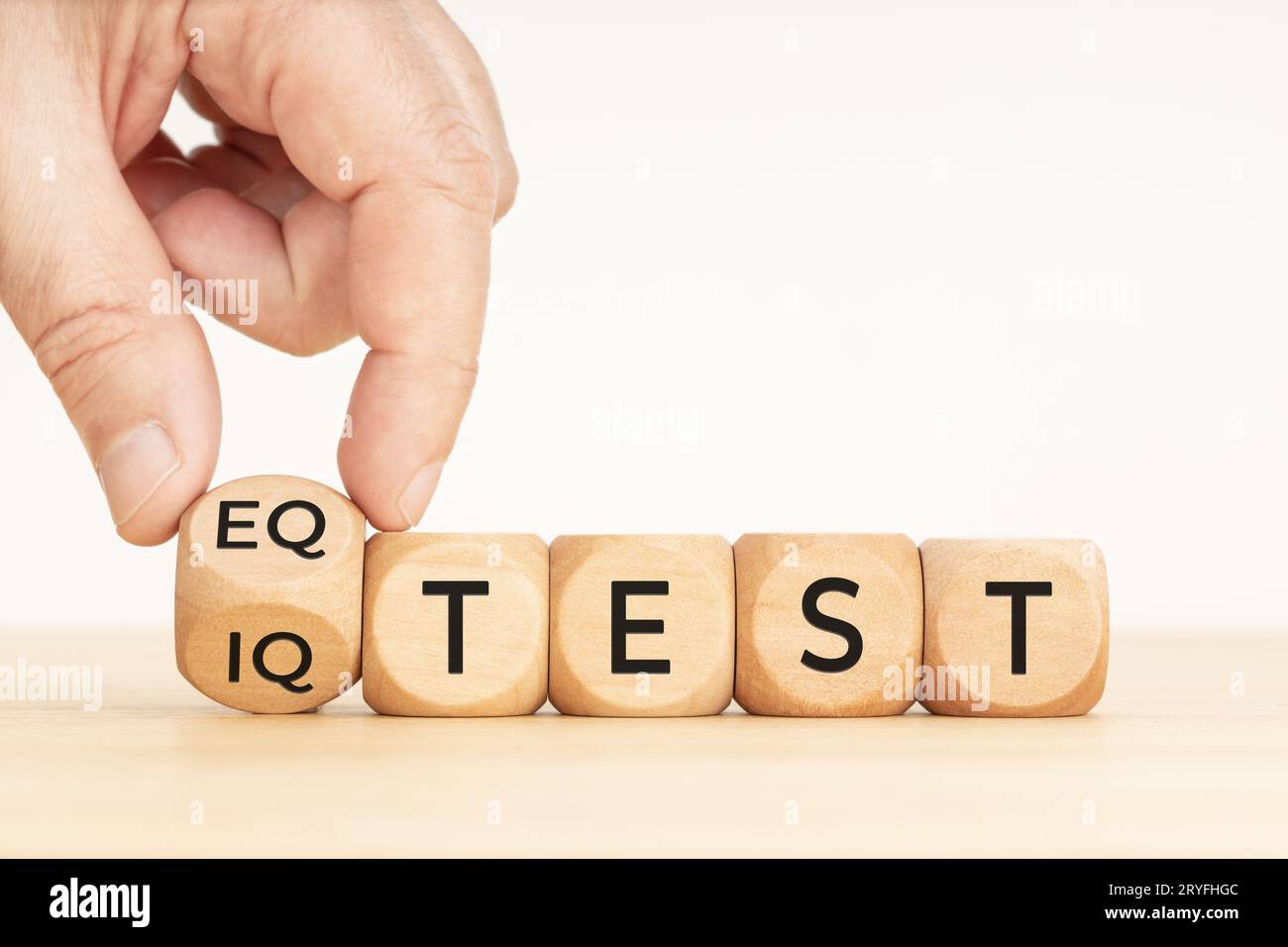 Handdrehung eines Holzblocks mit EQ-Test und iq-Testphase. Speicherplatz kopieren. Weißer Hintergrund Stockfoto