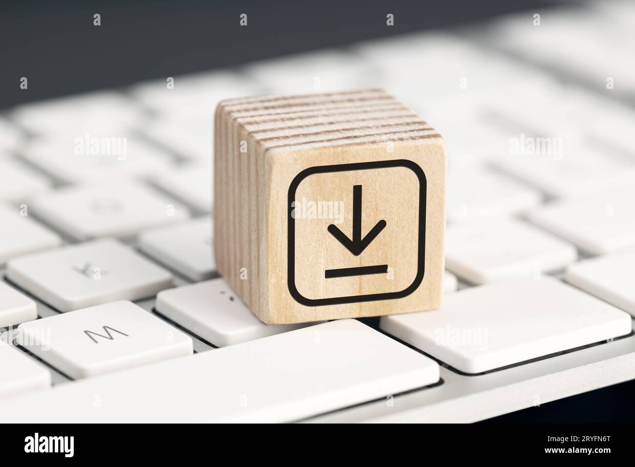 Download-Symbol auf Holzblock auf Computer-Tastatur. Datenspeicherung wird heruntergeladen Stockfoto