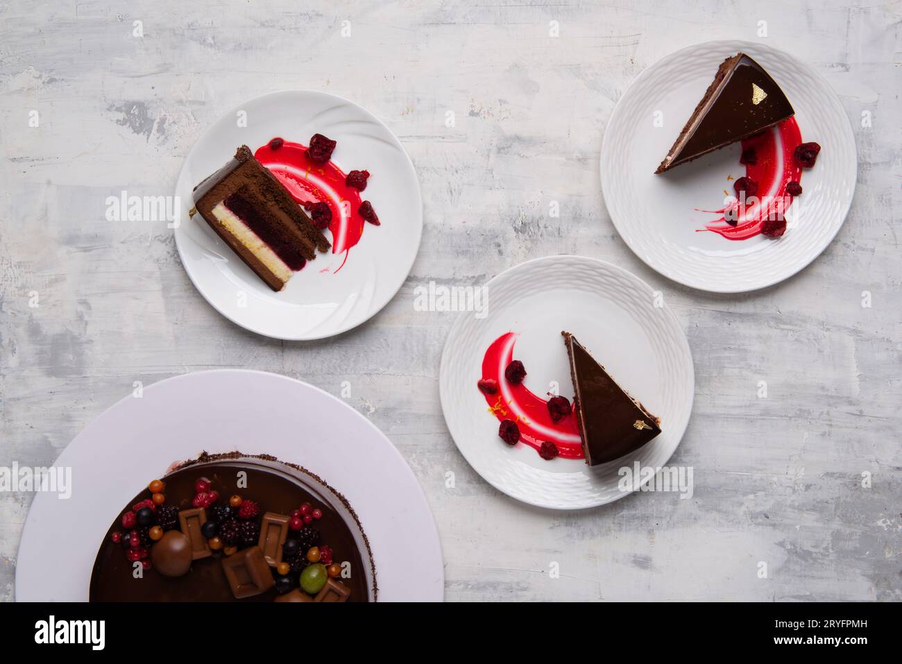 Top-Shot mit leckeren Schokoladenkuchen, serviert mit einer Beerensauce auf Tellern. Stockfoto