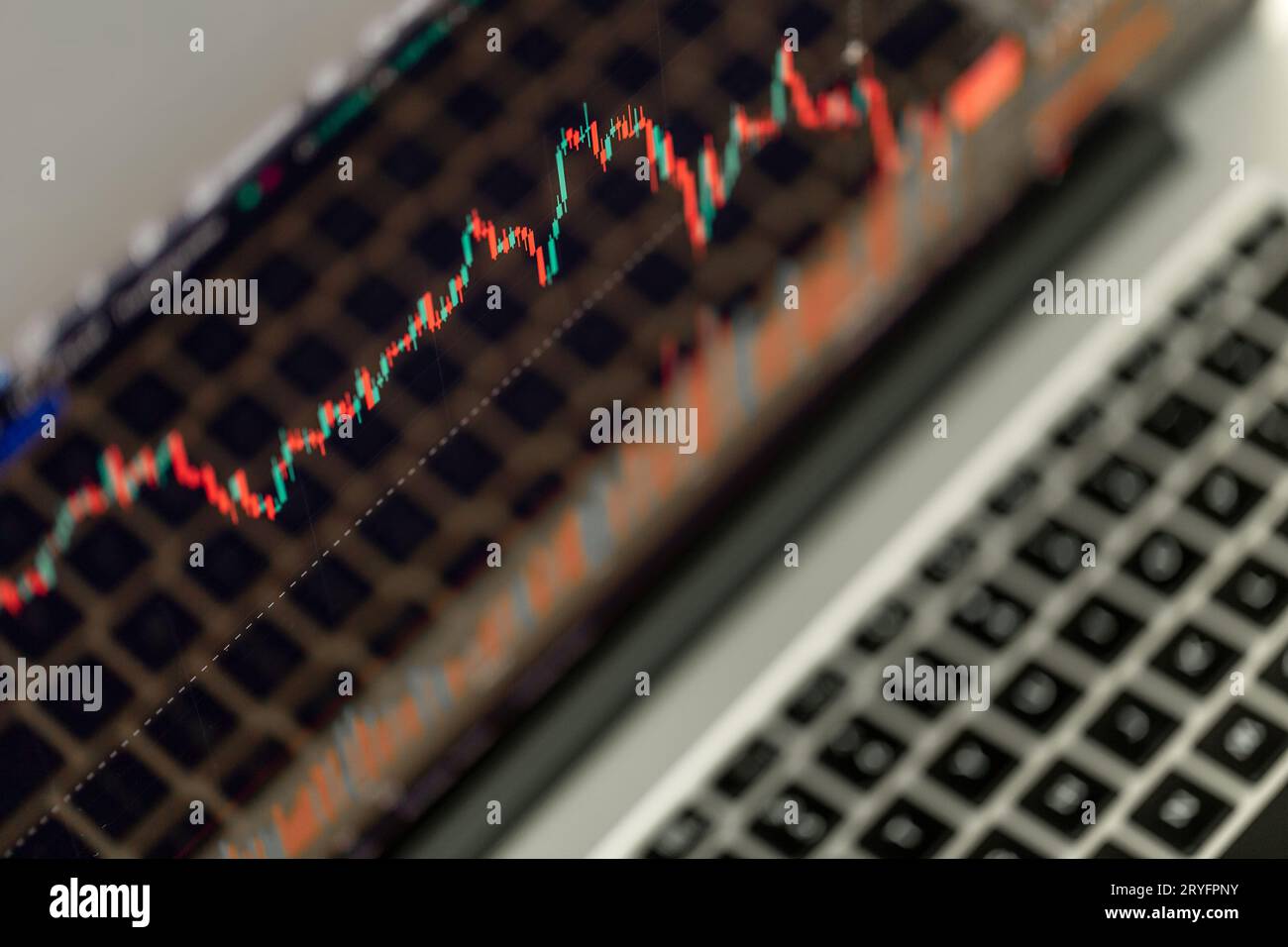 Nahaufnahme eines Handelsdiagramms, der auf dem Bildschirm des Laptops angezeigt wird. Börse, Trendlinie in Kerzenform. Stockfoto