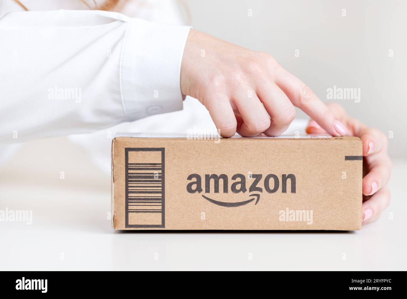 Frau, die den Karton öffnet, geliefert von Amazon, Hände nur im Rahmen Stockfoto