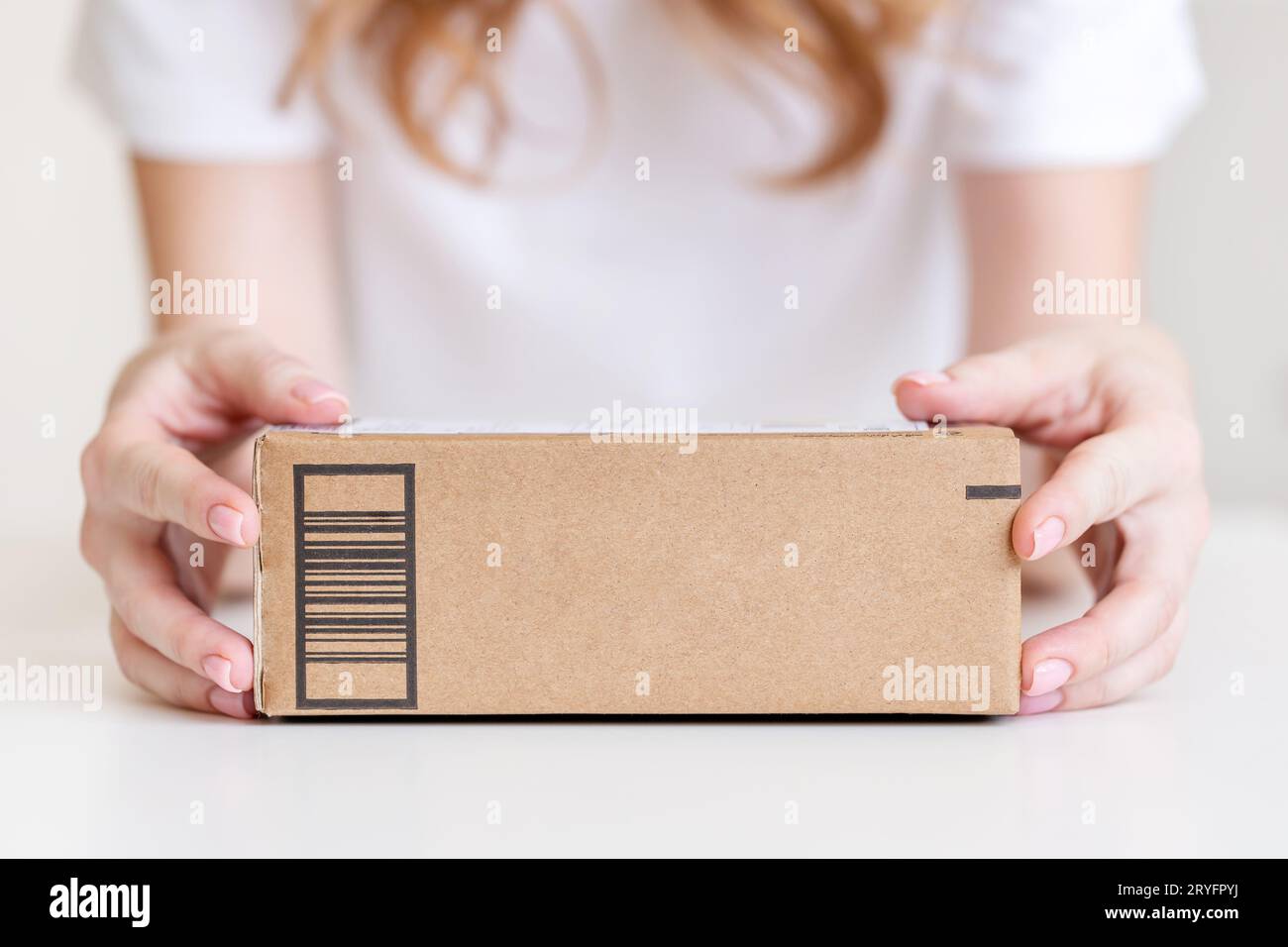 Frau, die in Händen hielt, lieferte Waren in Pappkarton. Ansprechendes Design mit Kopierraum. Stockfoto