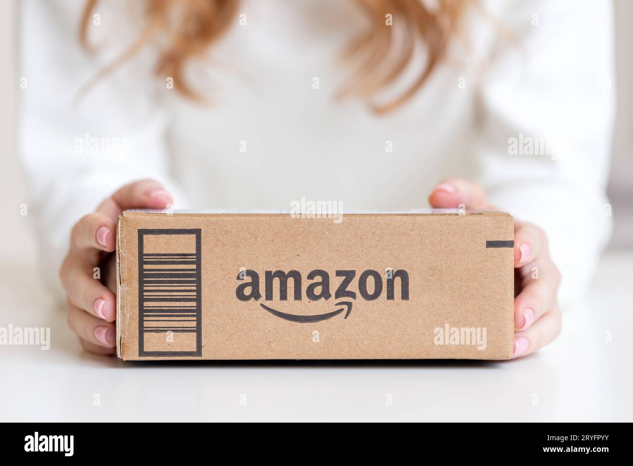 Frau in Händen, die von Amazon in Kartons geliefert wurde Stockfoto