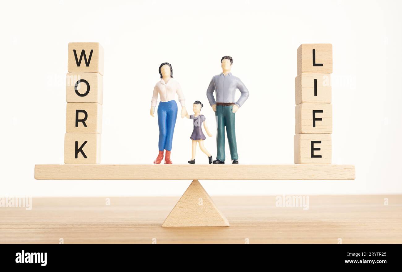 Balance zwischen Leben und Arbeit Konzept. Familienfiguren und Holzblöcke mit Wort auf Seesaw Stockfoto
