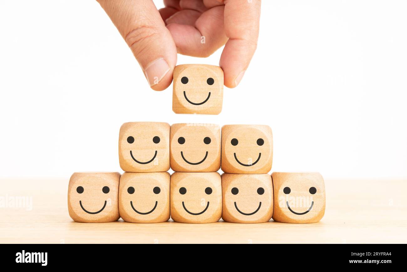 Erstklassige Kundenerfahrung im Bereich Business Service. Hand setzen Holzblock Form mit Symbol Gesicht Smiley Stockfoto