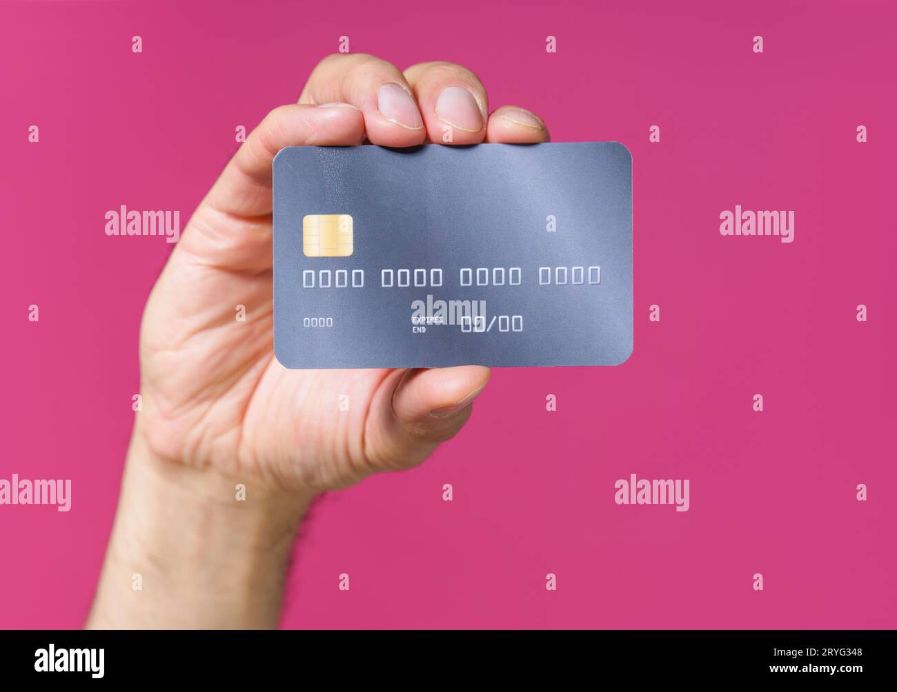 Bestes Angebot, dunkelgrau-lila Debit, Kreditkarte in Mannhand isoliert auf rosa Hintergrund. Finanz- und Bankkonzept. Keine Gesichtsvisiere Stockfoto