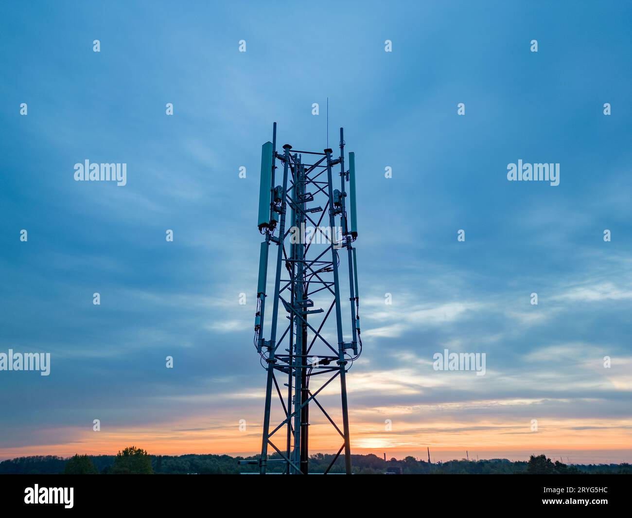 3G, 4G, 5G Mobiltelefon-Basisstation Tower. Entwicklung des Kommunikationssystems im nicht-städtischen Waldgebiet mit dunklem Sonnenuntergang oder Su Stockfoto