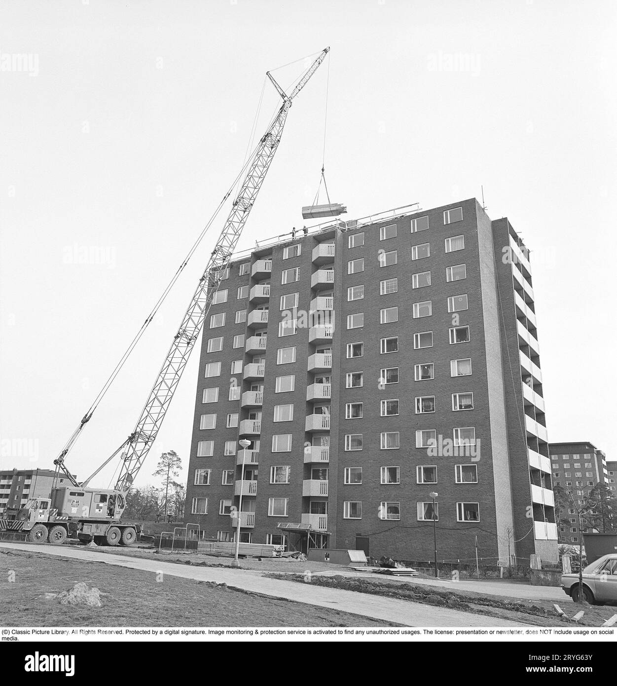 Ein Haus wird in den 1970er Jahren gebaut Das so genannte Million-Programm, das in den 1970er Jahren in Schweden der gebräuchliche Name für den Wohnungsbau war und das Stockholmer Wohnungsknappheit lösen sollte. Wohnungen in Hochhäusern wurden in vielen Wohngebieten zur Lösung. Hier ein neu errichtetes Hochhaus, in das viele bereits eingezogen sind, obwohl der Bau noch nicht vollständig abgeschlossen ist. Schweden 1975. Kristoffersson ref EF70-7 Stockfoto