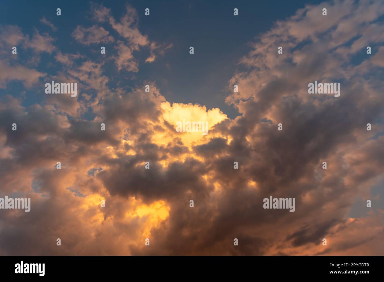 Perfekter Hintergrund helle goldorange Wolken, die von Sonnenlicht beleuchtet werden. Sommerabend mit hellem Himmel, der Ihre Fotos überlagert Stockfoto