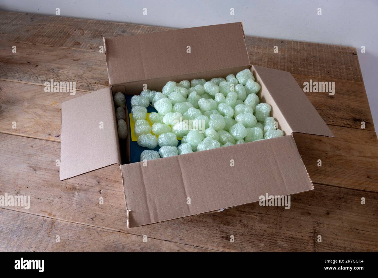 Amsterdam Niederlande biologisch abbaubares Verpackungsmaterial, das mit einer Verpackung von de Bolster, einem niederländischen Saatguthändler, versandt wird. Die Verpackung besteht aus Stärke aus pflanzlichen Rückständen und kann direkt auf den Kompost aufgesetzt werden. Verpackungsabfälle, insbesondere aus Versandverpackungen, sind ein wesentlicher Teil des weltweiten Abfalls. Indem Versandunternehmen die Verpackung leicht recycelbar machen, können sie den Kreis schließen. In diesem Fall geht die Verpackung direkt zum Kompost, um Boden herzustellen, in dem die Samen angebaut werden. Opvulmateriaal, biologisch, afbreekbaar, restmateriaal, Kompost, composteren, vlokken, Stockfoto