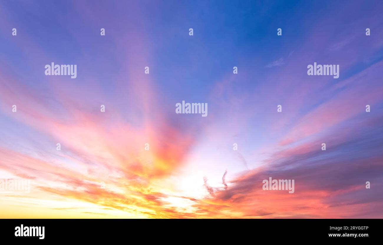 Wilder, feuriger Abendhimmel mit Wolken kurz vor Sonnenuntergang Stockfoto
