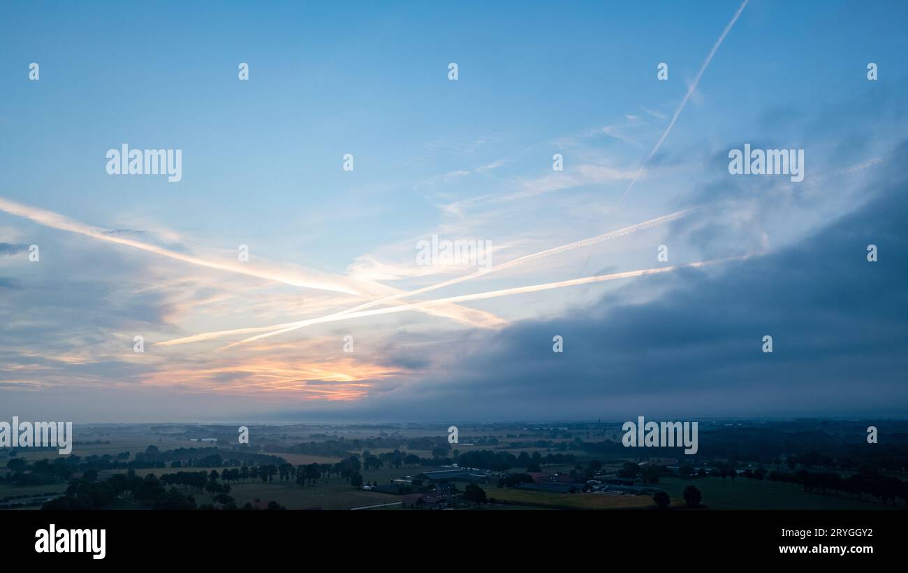 Luftaufnahme eines Abendhimmels über den Feldern, bedeckt mit Gewitterwolken, die beim Sonnenaufgang oder Sonnenuntergang eintreffen, aufgenommen mit Stockfoto