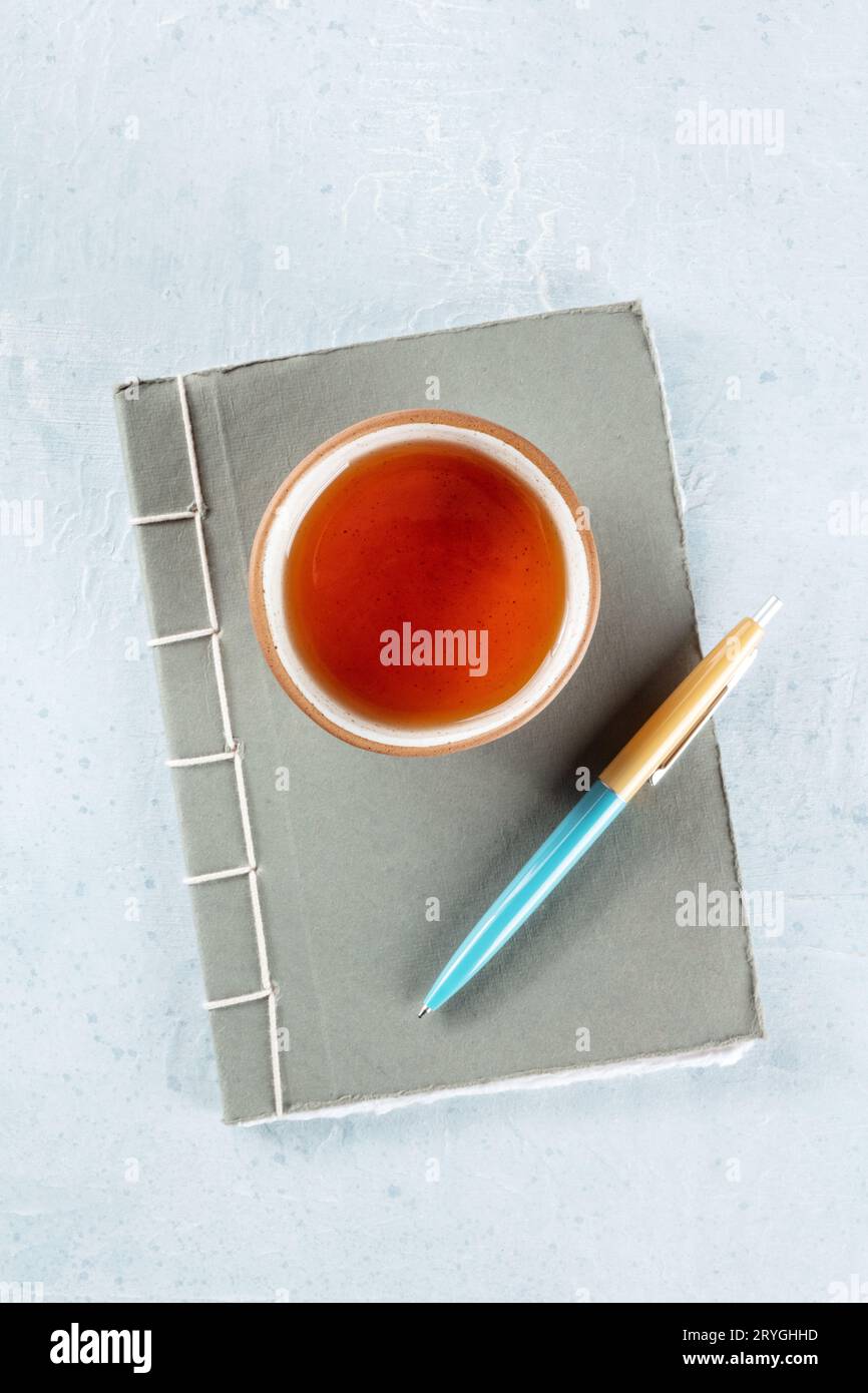 Ein Tagebuch. Ein Tagebuch aus Papier mit Stift und einer Tasse Tee, minimalistischer Stil Stockfoto