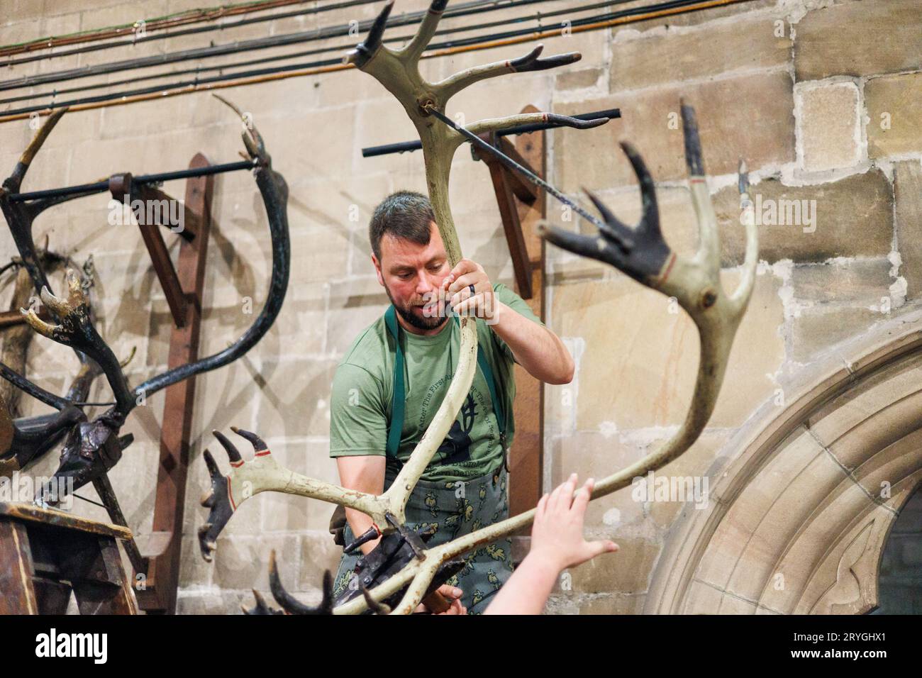 Horn Dancer Joe Bailey beginnt, die Hörner in St. zu entriegeln und aus ihren Rahmen zu entfernen Die Nikolaikirche ist bereit, zu Beginn des Tages gesegnet zu werden. Die Abbots Bromley Horn Tänzerinnen, während sie sich zu Beginn des Tages um Abbots Bromley herum tanzten. Der Tanz wird seit 1226 aufgeführt. Geweihe werden um 7:45 Uhr aus der örtlichen Kirche entfernt, gesegnet und die Tänzer führen dann ihre Tänze in lokalen Dörfern bis 20:00 Uhr auf, wenn wieder einmal das Geweih für ein weiteres Jahr weggesperrt wird. Das jährliche Ritual beinhaltet Rentiergeweihe, ein Hobbypferd, Maid Marian und einen Narren. Stockfoto