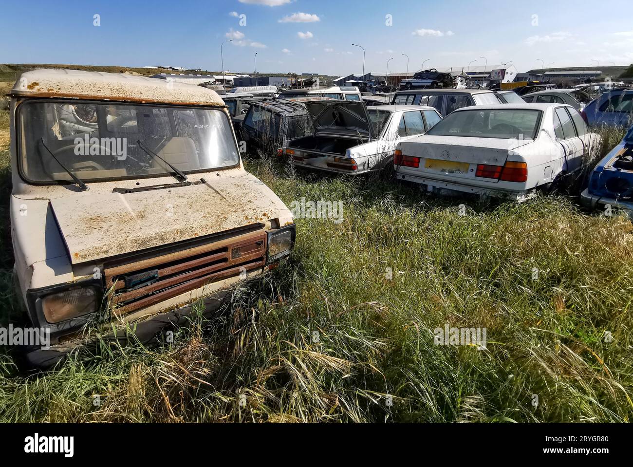 Autojunkyard im Freien mit Wrack eines zerstörten Autos. Umweltverschmutzung Metallrecycling. Stockfoto