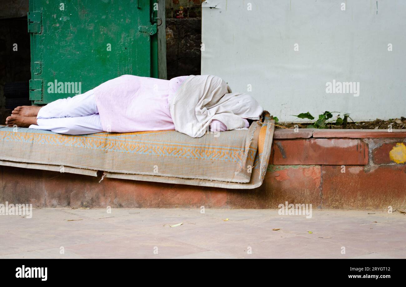 Ein Obdachloser, der draußen auf der Straße schläft. Hilflose Menschen in der Stadt Stockfoto