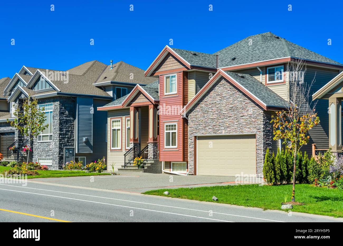 Neues Familienhaus mit Betonauffahrt und Asphaltstraße vor dem Hotel. Stockfoto