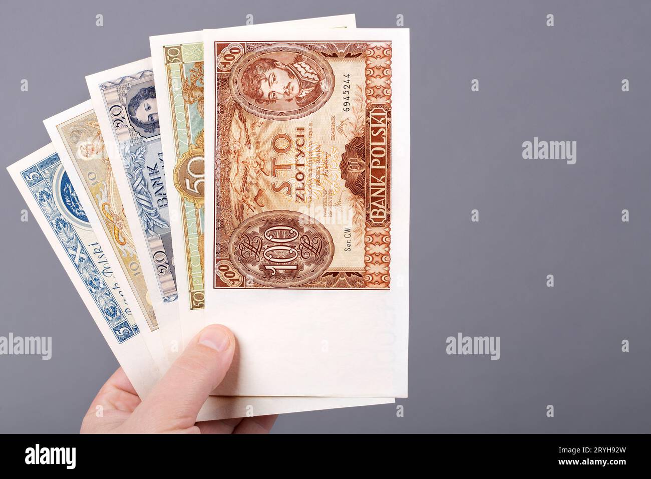 Der alte polnische Zloty in der Hand auf grauem Hintergrund Stockfoto