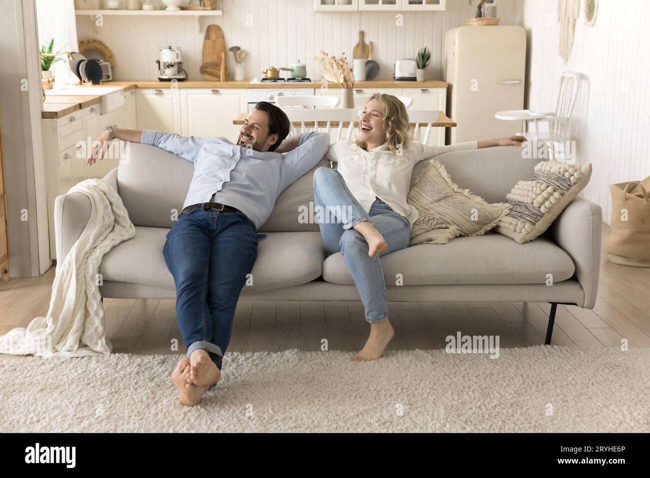 Glückliche Ehepartner entspannen sich auf dem gemütlichen Sofa im neuen Haus Stockfoto