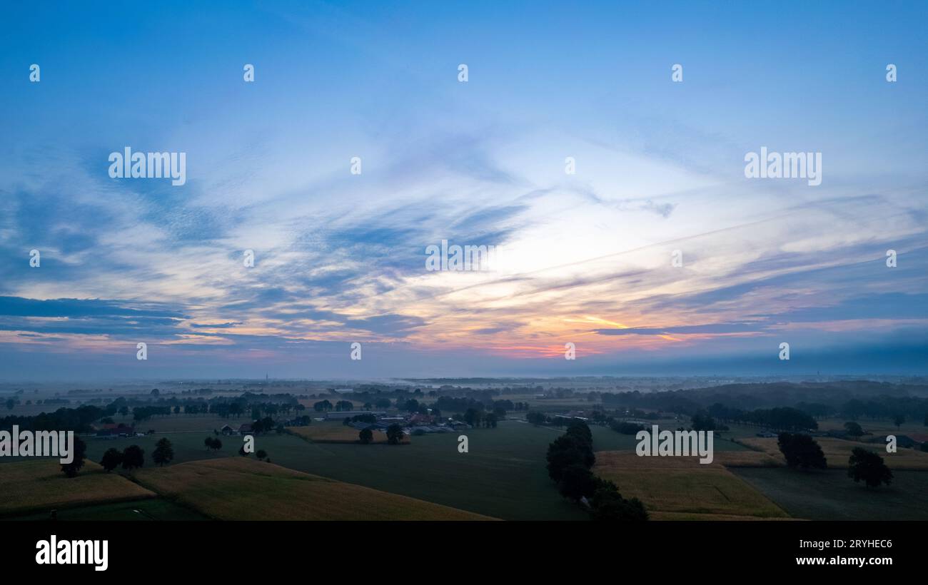 Luftaufnahme eines Abendhimmels über den Feldern, bedeckt mit Gewitterwolken, die beim Sonnenaufgang oder Sonnenuntergang eintreffen, aufgenommen mit Stockfoto