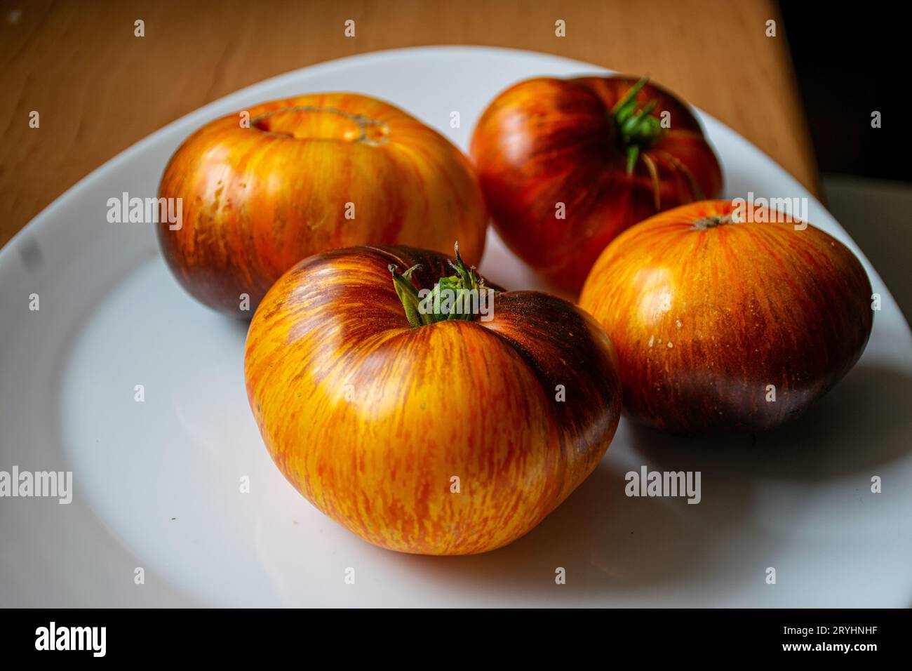 Bunte, saftige, gesunde Tomaten auf einem Teller, leckere und gesunde Ernährung, für Vegetarier geeignet Stockfoto