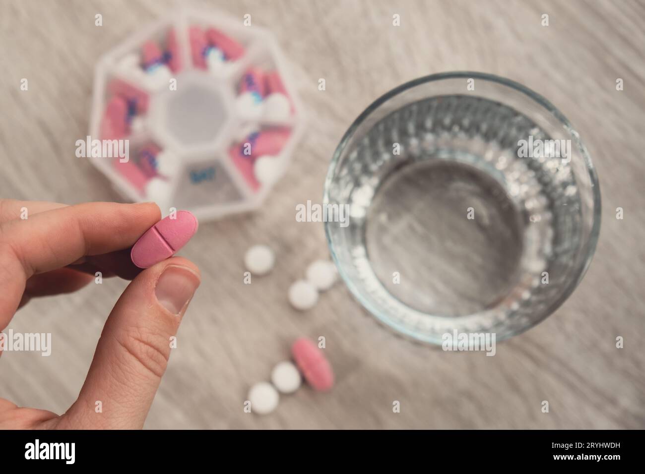 Frau sortieren Pillen Organisator wöchentliche Schüsse Closeup der medizinischen Pille Box mit Dosen von Tabletten für tägliche Einnahme Medizin mit weiß Stockfoto