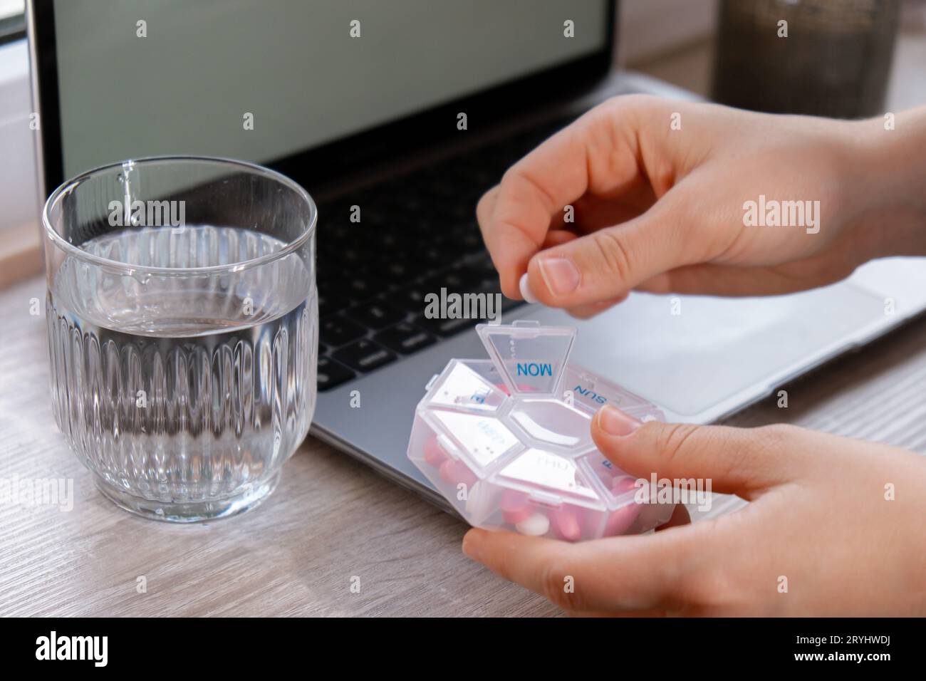 Frau sortieren Pillen Organisator wöchentliche Schüsse Closeup der medizinischen Pille Box mit Dosen von Tabletten für tägliche Einnahme Medizin mit weiß Stockfoto