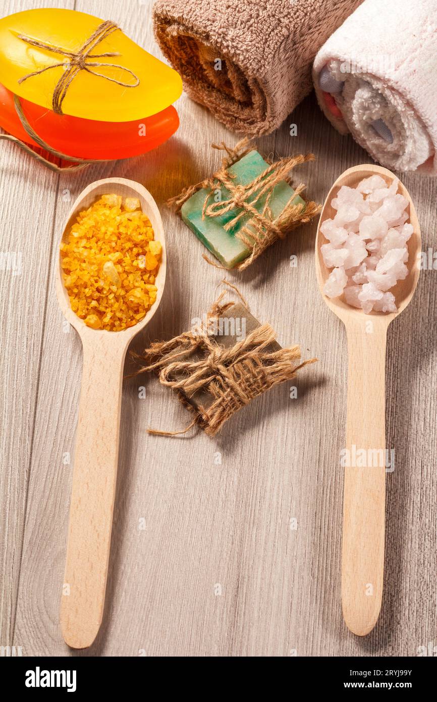 Holzlöffel mit gelbem und weißem Meersalz und handgemachter Seife Stockfoto